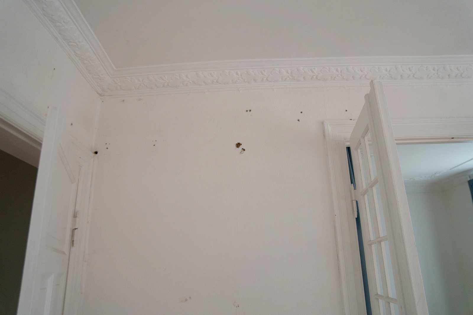 Detalje af de slidte vægge med huller under stukfrisen, før spartling, filtning og maling
